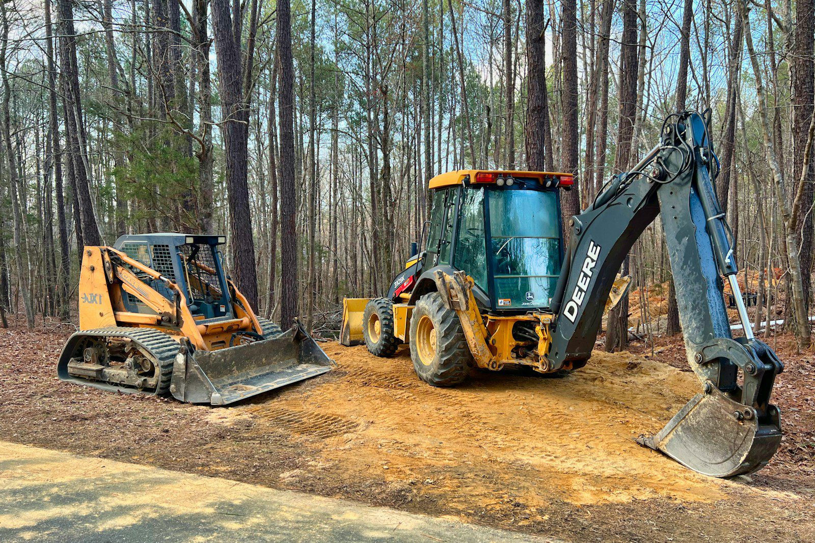 a tractor and a bulldozer are parked on a dirt road